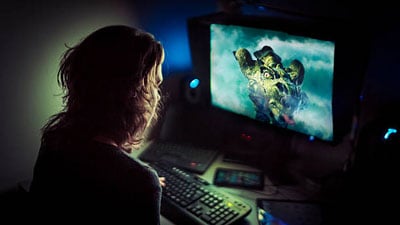 A female graphic designer working at her desk in the dark